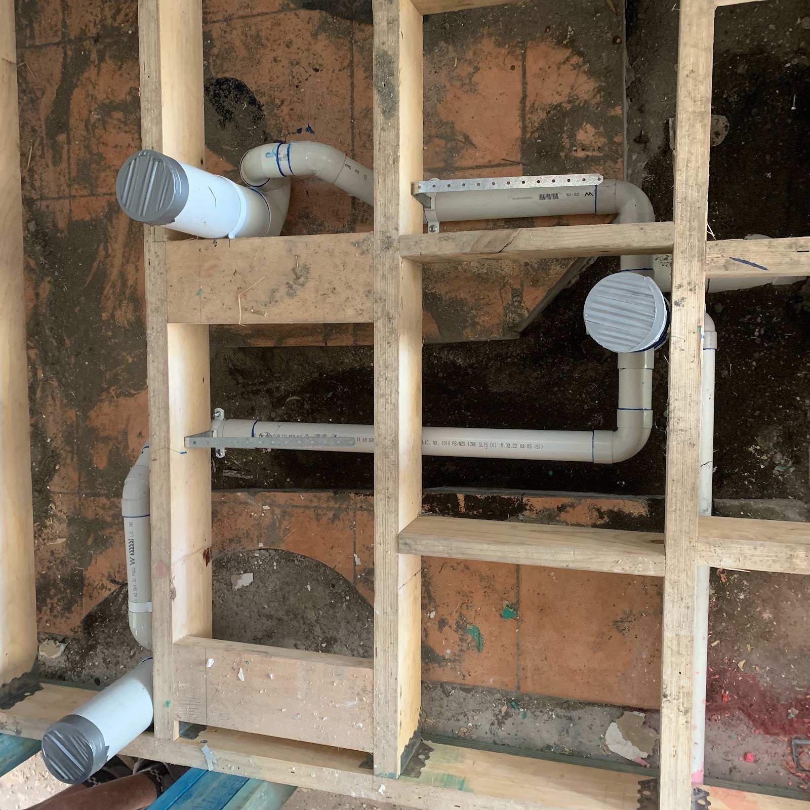 New drainage pipes run beneath a timber floor frame